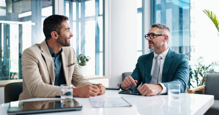 Business, meeting and men talking in office of brainstorming, financial planning and company. People, discussion and documents with finance growth, investment report and feedback idea for opportunityの写真素材