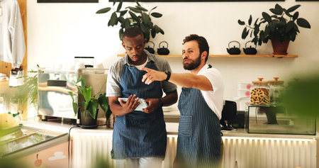 Pointing, men and baristas planning in coffee shop for grand opening with startup, restaurant or business. Teamwork, tablet and waiters with online stock order for cafe with technology together.の写真素材