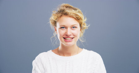 Portrait, smile and space with student woman in studio for college, school or university study. Confident, education and mockup with German person on gray background for development or learningの写真素材