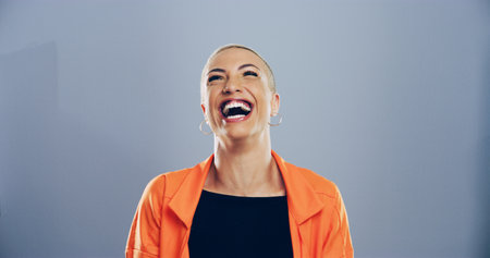 Crazy, woman and happy for laugh in studio with confidence, joke and good mood on gray background. Space, excited model and smile with fun personality for comedy, humor or funny reaction to memeの写真素材