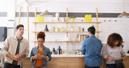 Coffee shop, group and people waiting at counter with smartphone, small business or hospitality. Relax, customer or friends at trendy cafe for morning drinks, lunch break or online review for serviceの写真素材