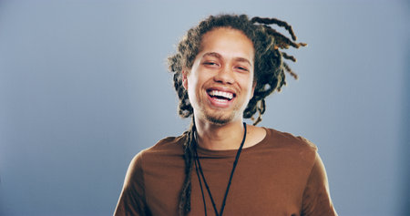 Portrait, man and laughing in studio for humor, lol and smile for comedy isolated on gray background with space. Face, funny and happy African person with joke, goofy and excited with comic emotionの写真素材