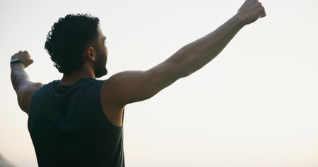 Winner, fitness and back of man in nature for mockup space, success and health. Runner, workout and freedom with male person and training with sky view for sports athlete, marathon and exerciseの写真素材