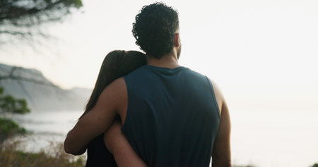 Fitness, couple and hug with view of nature, outdoor and training break for sightseeing. Exercise, man and embrace woman by sea to rest for body health, love or back together for wellness by oceanの写真素材