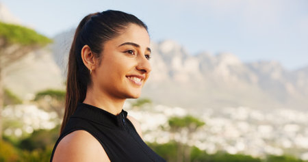 Smile, fitness and girl with thinking outdoor for running break, mountain view or resting in nature. Space, relax and runner with scenery for marathon exercise, workout performance or cardio trainingの写真素材