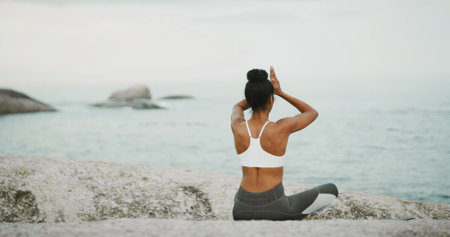 Ocean, calm and meditation for woman, outdoor and spiritual practice for wellness, peace and relax. Back, chakra and self awareness with person, mindfulness and yoga with prayer hands for zenの写真素材