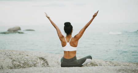 Ocean, freedom and meditation for woman, outdoor and spiritual practice for wellness, peace and relax. Sea, chakra and self awareness for person, back and yoga with mindfulness benefits or zenの写真素材