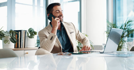 Phone call, office and business man on laptop for contact, online discussion and communication. Corporate, company consultant and person talking on smartphone for networking on computer for researchの写真素材