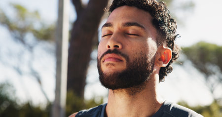 Calm man, breathing and fitness with mindfulness in nature for zen, workout or exercise at outdoor park. Face, male person or eyes closed with peace or spiritual technique for health, rest or breakの写真素材