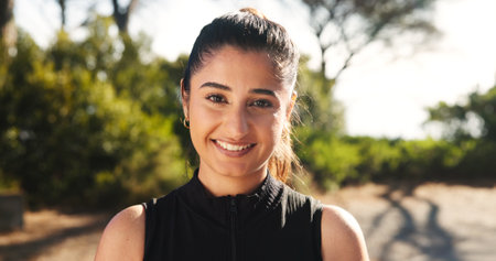 Outdoor, woman and smile in portrait for fitness, running challenge and confidence for health. Happiness, female person and runner with positive attitude for exercise, cardio and wellness in natureの写真素材
