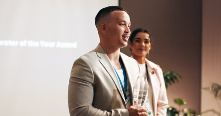 Business, man or speech in award ceremony for trophy, achievement or winning at seminar. Man, presentation or comment with smile for accomplishment, milestone or employee of month at workshopの写真素材