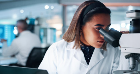 Scientist, woman and microscope in lab, study and process for medical research for human genome sequence. Person, review and test for sample with clinical trial, investigation and DNA analysisの写真素材
