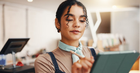 Employee, stylus and woman in coffee shop, tablet and check inventory with ecommerce. Person, restaurant host and business owner in cafe, tech or online order with digital app for menu or hospitalityの写真素材