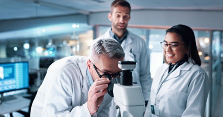 Research, teamwork and microscope with people in laboratory for DNA discovery, healthcare or solution. Gene study, medical and clinical trial with scientist in clinic for science, results and biotechの写真素材