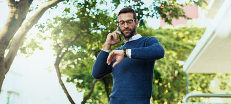 Late, city and man with watch, phone call and waiting for transport in morning, employee and serious. Outdoor, commuting and checking time for appointment, travel and person with mobile for meetingの写真素材