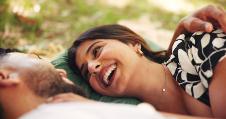 Outdoor, relax and couple on date, picnic and smile for conversation in nature, embrace and relationship. Happy, man and bonding with woman on anniversary, people and together for romance or loveの写真素材
