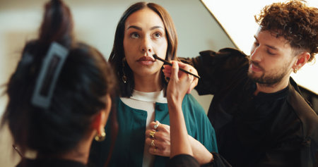 Photography, backstage and woman with styling team in studio for production, preparation or photoshoot. Creative, media and female model with makeup artist and hairdresser for magazine editorial.の写真素材