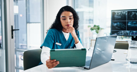 Woman, nurse or research with tablet on laptop for medical discovery, study or reading at hospital. Female person, healthcare worker or employee with technology for telehealth or health app at clinicの写真素材