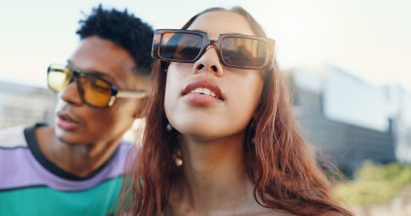 Sunglasses, trendy and couple in city with fashion in summer for urban, edgy and cool style together. Streetwear, gen z woman and creative people in town for youth culture, unique outfit and swagの写真素材