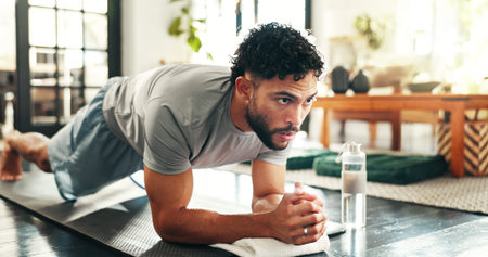 Fitness, man and plank in home for workout, training or thinking of balance. Core exercise, muscle or strong person on floor for body strength, health or wellness with endurance challenge for pilatesの写真素材