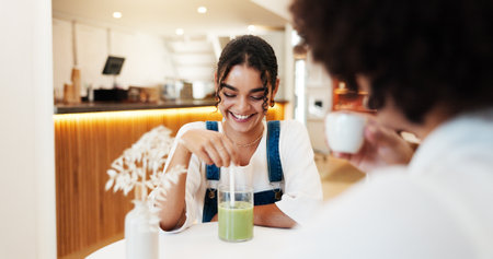 Happy, drinks and couple in coffee shop on date for bonding, relationship and relax. Restaurant, cafe and man with woman with matcha beverage for conversation, talking and chatting on weekendの写真素材