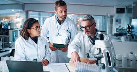 Collaboration, science and teaching with people in laboratory together for breakthrough or development. Laptop, microscope or tablet and research team with mentor in clinical trial for medical studyの写真素材