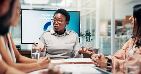 Office, people and businesswoman with discussion in meeting, employees wellness and health program. Boardroom, colleagues and HR manager with feedback in workshop, support policy and review reportの写真素材