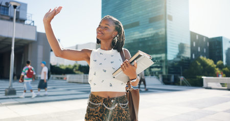University student, girl and books with greeting outdoor for hello, friendly interaction and respect. Education, black person and wave on campus for morning routine, study scholarship and learningの写真素材