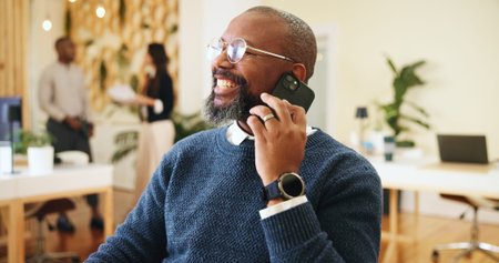 Phone call, smile and man in office, talking and consultation for update on publication or conversation. Communication, publisher and discussion with contact for deadline, happy and mature personの写真素材