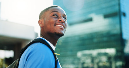 Happy, black man and thinking student in city for medical study, planning and healthcare opportunity. Smile, person or morning commute of learning internship, academic scholarship and nursing programの写真素材