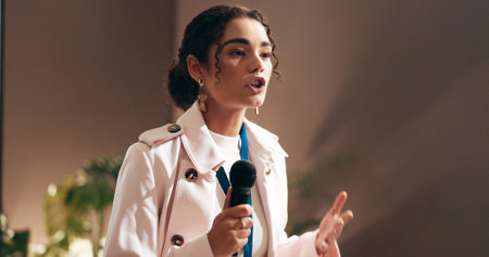 Woman, presentation and talking at convention with microphone, speech and discussion at workshop. Person, public speaking and advocacy for staff wellness, stage and corporate seminar in auditoriumの写真素材