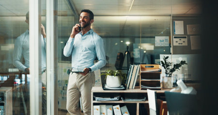 Happy, businessman and tablet with phone call in office, finance advice and listen to client. Reflection, male person and financial advisor with mobile for networking, negotiation and laugh at nightの写真素材
