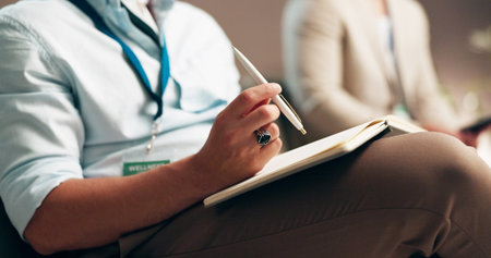 Business person, hands and writing with notebook in seminar for learning, education or notes of...