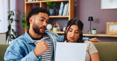 Couple, paper and budget planning in home, mortgage expenses or insurance application. Living room, man and woman with document for financial discussion, taxes or bills for asset management with debtの写真素材