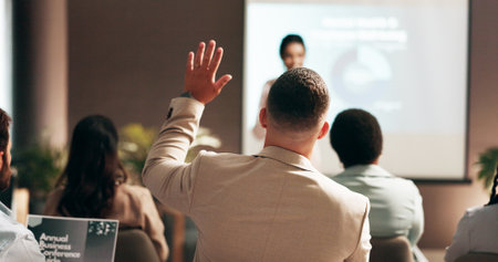 Audience, back and question with business people in conference room of convention center. Crowd, hand raised and volunteer with professional employee in office for upskill seminar or workshopの写真素材