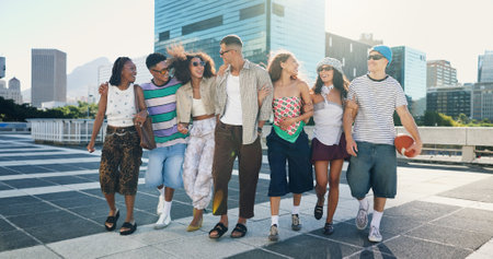 Cool, walking and friends in city with fashion in summer for urban, edgy or trendy style together. Diversity, gen z men and group of creative women in town for street culture, unique clothes or swagの写真素材