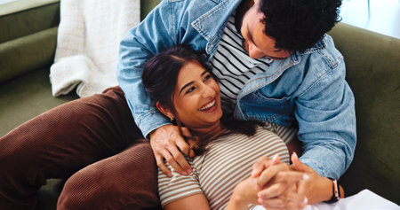 Happy couple, relax and laughing with sofa for funny joke, bonding or humor together at home. Woman, man and care with love, comedy or weekend with smile for holiday, comfort or romance at houseの写真素材