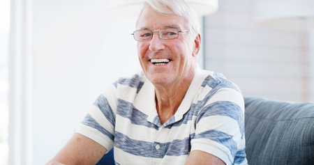 Laugh, sofa and portrait of senior man in home for relaxing, resting and comfortable in morning. Retirement, house and mature person with smile for calm, peace and wellness in living room on weekendの写真素材