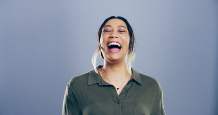 Comic, woman and portrait for laugh in studio with confidence, joke and good mood on gray background. Space, excited model and smile for carefree personality, comedy and humor or funny meme reactionの写真素材