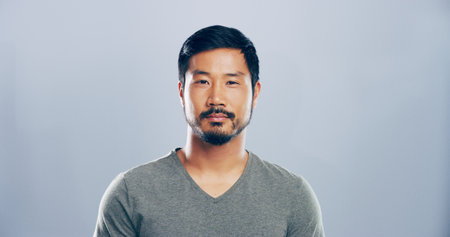 Portrait, serious and creative Asian man in studio for ambition, career opportunity or pride. Face, confidence and worker, business professional or copywriter on gray background with space in Koreaの写真素材