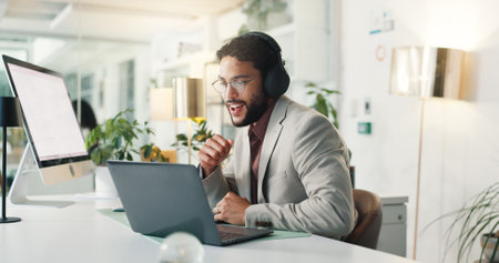 Laptop, video call and businessman with headphones in office for online global team with meeting. Audio tech, computer and financial advisor on virtual discussion for investment plan in workplace.の写真素材