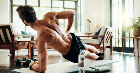 Plank, stretching and man in home, exercise and balance for core muscles in living room and back. Morning, training and person with routine in lounge, posture and wellness with workout in houseの写真素材