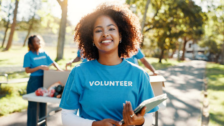 Nature, woman and portrait of volunteer with tablet for checking food drive donation list. Confident, outdoor and female NGO worker with digital technology in park for nonprofit or charity event.の写真素材