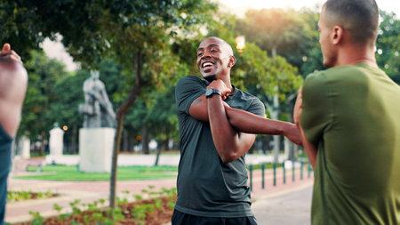 Fitness, stretching and men with routine, outdoor and happy for exercise in morning, athlete or sports. Park, team and people with smile for workout, warm up and friends in nature, runner and healthyの写真素材