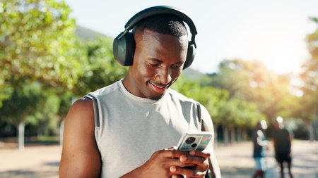 Outdoor, black man and music with mobile for fitness, training and happy with audio track. Nature, male person and runner with headphones to listen, radio and smartphone with song for exerciseの写真素材