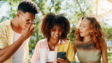 Friends, online and surprised with phone at park for social media update, gossip post and drama news. Gen z people, shocked and smartphone with reading information, announcement or chat notificationの写真素材