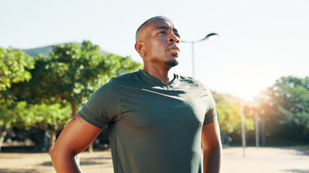 Outdoor, black man and fitness with thinking for rest, cardio challenge and breathing after running. Nature, male person and runner with thoughts on break, tired and wellness with health for exerciseの写真素材
