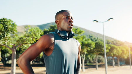 Outdoor, black man and rest with thinking for fitness, cardio challenge and exhausted after running. Nature, male person and runner with thoughts on break, tired and wellness with health for exerciseの写真素材