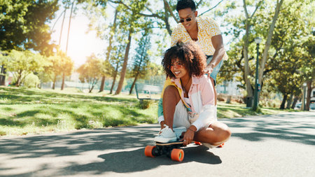 Fun, skateboarder and couple in city, smile and travel on road with skateboard, laughing or outdoor. Journey, man and woman on date, trip and bonding for commitment in relationship on street or happyの写真素材
