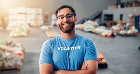 Happy, man and portrait of volunteer at food drive for charity, donation or non profit event. Confident, activism and face of male NGO worker at community center for help in society at workshop.の写真素材